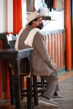 SALENTO, COLOMBIA - JULY 2021. Senior local man wearing traditional poncho and hat at the beautiful streets of Salento an small town located at the Quindio region in Colombiaのeditorial素材