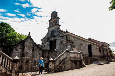 Senior woman at the beautiful historical church La Ermita built in the sixteenth century in the town of Mariquita in Colombiaの写真素材