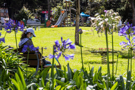 BOGOTA, COLOMBIA - NOVEMBER, 2020: Young woman enjoying a sunny day at the beautiful gardens of the...
