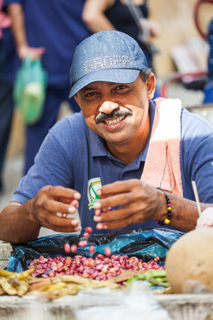 CARTAGENA DE INDIAS, COLOMBIA - AUGUST, 2011: Street vendor shucking beans at Cartagena de Indias city centerのeditorial素材