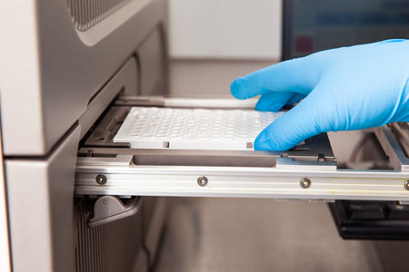 Scientist loading samples to a RT-PCR thermal cycler at the laboratory. Real-time polymerase chain reaction technique. RT-PCR techniqueの写真素材