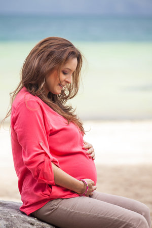 Portrait of a young woman waiting for her baby at the beautiful white beach of Lake Tota located in...