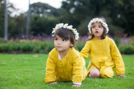 Beautiful little sisters dressed in yellow playing and having fun outdoors. Happiness concept. Family conceptの写真素材
