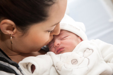 Newborn girl with her mom in the hospital on the day of her birth. Motherhood conceptの写真素材