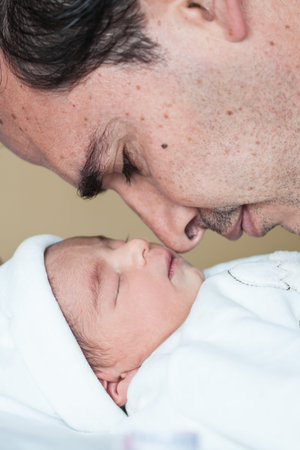 Newborn girl with her dad in the hospital on the day of her birth. fatherhood concept