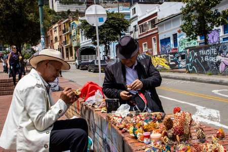 Bogota, Colombia - July 2nd 2023. Senior artisans selling pretty handmade birds made from seeds on the streets of downtown Bogota.のeditorial素材