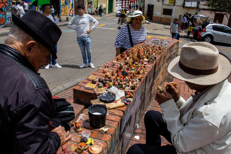 Bogota, Colombia - July 2nd 2023. Senior artisans selling pretty handmade birds made from seeds on the streets of downtown Bogota.のeditorial素材