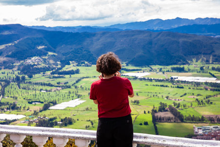Young woman at a viewpoint over the beautiful Sopo valley at the department of Cundinamarca in Colombiaの写真素材