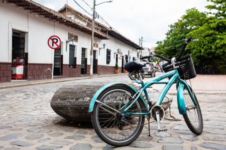 Vintage blue bike parked at the beautiful streets around the central square of the Heritage Town of Guaduas located in the Department of Cundinamarca in Colombia.のeditorial素材