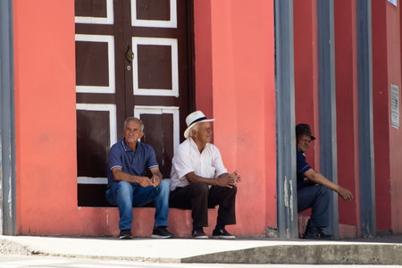 SALAMINA, COLOMBIA - JANUARY 14, 2024: Senior men sitting at the entrance of the Mayors Office Building of the beautiful heritage town of Salamina in the department of Caldas in Colombia.のeditorial素材