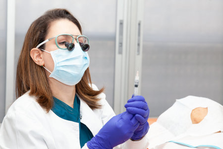 Dermatologist carrying out a skin biopsy on the face of a senior adult patient. Application of...