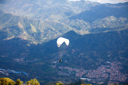 People paragliding over the beautiful mountains of the Antioquia department in Colombia. Tandem Paragliding. Extreme sport concept.の写真素材