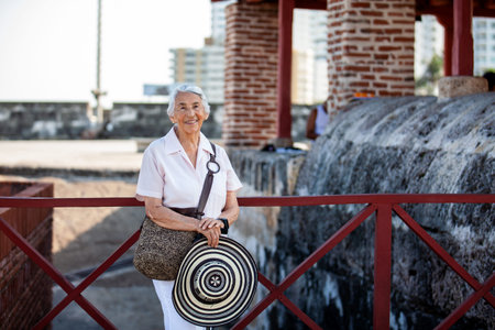 Senior woman tourist holding a vueltiao hat in Cartagena. Active senior concept. Senior travel concept. Senior lifestyle.の写真素材