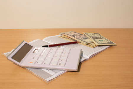 Notebook and calculator with dollarsの写真素材