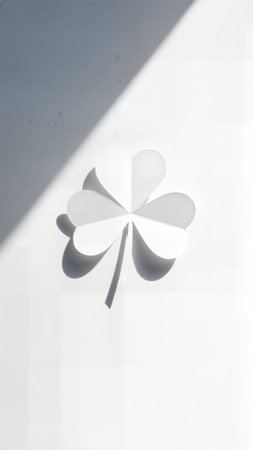 Minimalist white paper shamrock on a clean background with dramatic shadow and light contrastの素材