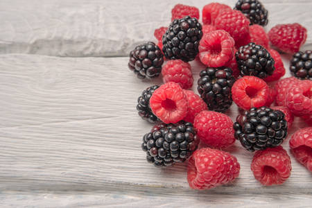 Ripe sweet raspberries and blackberries on wood table backgroundの写真素材