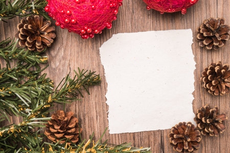 Christmas border design with pine cone, fir branches and christmas balls on parchment paper over old...