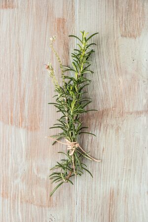 Bunch of fresh of garden rosemary on wooden table, rustic style, fresh organic herbs. Top view with copy spaceの写真素材