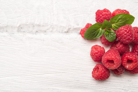 Ripe sweet raspberries on wood table background