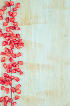 Red ripe peeled pomegranate on rustic wood board background. Top view, copy spaceの写真素材