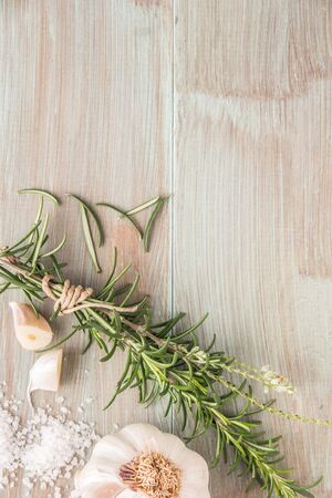 Bunch of fresh of garden rosemary on wooden table, rustic style, fresh organic herbs with salt and garlic.の写真素材