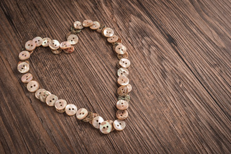 Valentine heart buttons textiles over rustic wooden texture. Top view with copy space.の写真素材