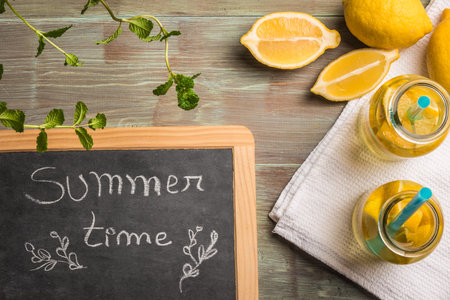 Glass of homemade lemonade with mint and lemon wedges. Top view with copy space.の写真素材