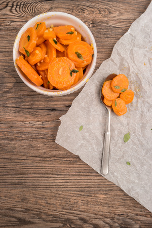 Healthy, organic sauteed carrots in a bowl garnished with thyme. Top viewの写真素材