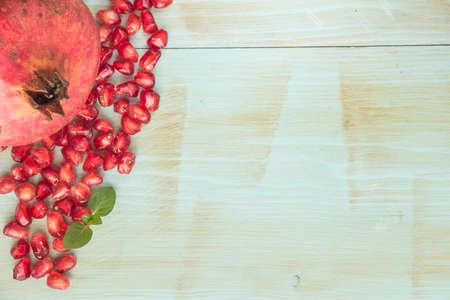 Red ripe peeled pomegranate on rustic wood board background. Top view, copy spaceの写真素材