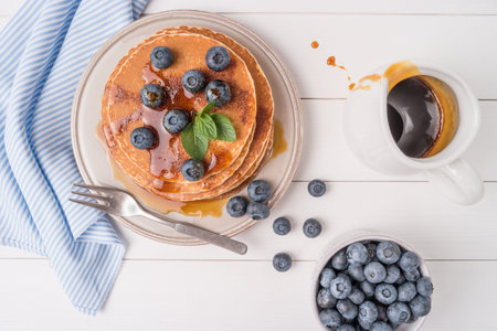 Stack of pancakes with fresh blueberry and caramel syrup. Top view
