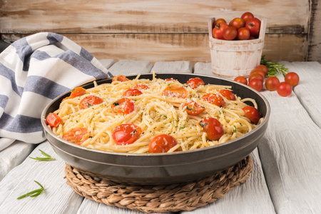 Spaghetti pasta with tomatoes and parsley on wooden tableの写真素材