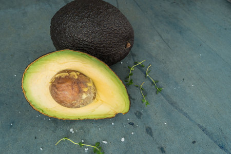 Fresh avocado sliced over vintage background close up. Ripe green avocado fruit on cement board.