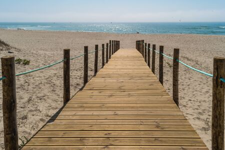 Wooden walkway over the sand dunes to the beach. Beach pathway in Praia de Paramos, Espinho, Portugalの写真素材