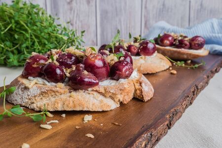 Toasts with goat cheese, grapes, nuts and honey.の写真素材