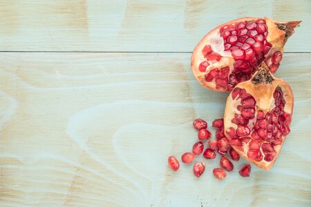 Red ripe peeled pomegranate on rustic wood board background. Top view, copy spaceの写真素材