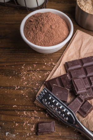 Dark chocolate and cocoa powder on rustic background and space for textの写真素材