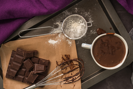 Delicious melted chocolate sauce in mug with whisk on table. の写真素材