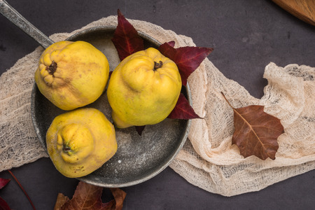 Quince fruits and marmelade in a ceramic bowl on table topの写真素材