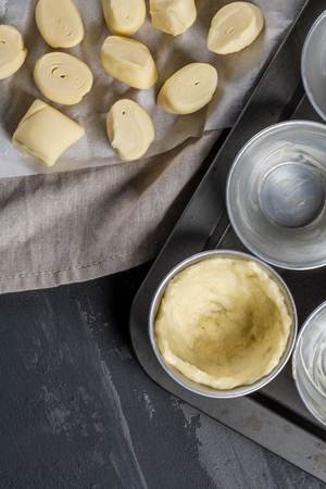 Ingredients for homemade baking portuguese egg tarts - flour, milk, water, egg, sugar, lemon, cinnamon, pastry and cake pan. Traditional portuguese dessert pastel de nataの写真素材