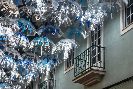 The beauty of white umbrellas iluminated by Christmas lights decorating the streets of Agueda Portugalの写真素材