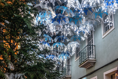 The beauty of white umbrellas illuminated by Christmas lights decorating the streets of Agueda Portugalの写真素材