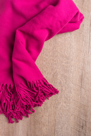 Woolen soft and worm scarf on rustic wooden background. Top view with copy spaceの写真素材