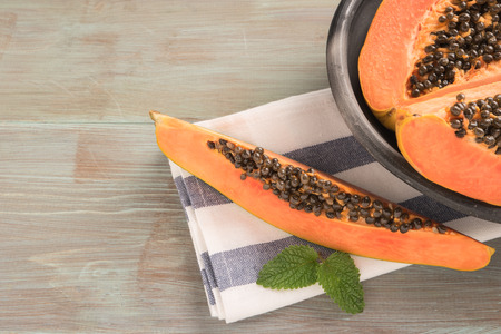 Sliced fresh papaya on wooden background. Top view with copy spaceの写真素材