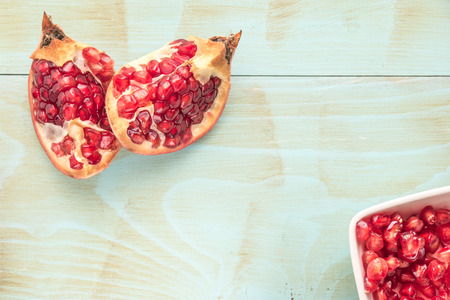 Red ripe peeled pomegranate on rustic wood board background. Top view, copy spaceの写真素材
