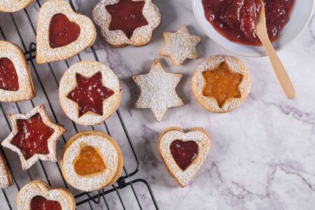 Flat lay with christmas cookies on marble surface with christmas decorative pine branch, jam, gift and cookie cuttersの写真素材