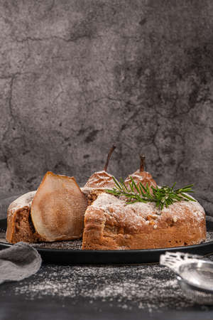 Delicious spice cake with pear, ginger and cinnamon on a dark kitchen counter.の写真素材