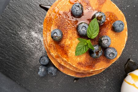 Stack of pancakes with fresh blueberry and caramel syrupの写真素材