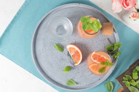 Grapefruit juice with mint in glasses on the table. Refreshing summer cocktail.の写真素材
