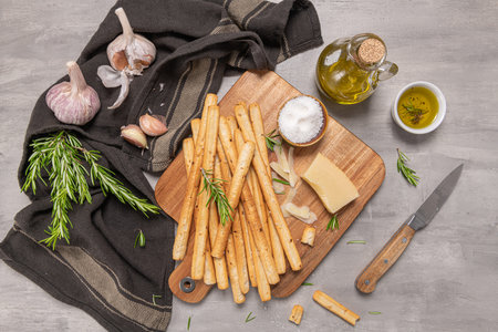 Traditional italian breadsticks grissini with rosemary, parmesan cheese, olive oil, garlic and salt...