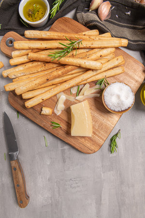 Traditional italian breadsticks grissini with rosemary, parmesan cheese, olive oil, garlic and salt...